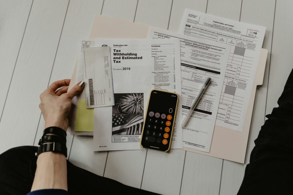 Two colleagues reviewing printed invoices and financial documents at a desk